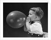 1940s boy blowing up balloon by Anonymous