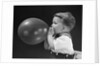 1940s boy blowing up balloon by Anonymous