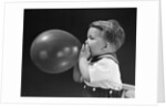 1940s boy blowing up balloon by Anonymous
