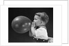 1940s boy blowing up balloon by Anonymous