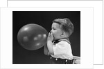 1940s boy blowing up balloon by Anonymous