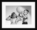 1950s little boy blowing up big balloon little girl with fingers in ears eyes closed by Anonymous