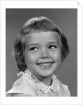 1960s smiling girl looking off to the side by Anonymous