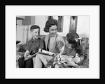 1960s mother sitting on couch with son and daughter by Anonymous