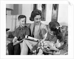 1960s mother sitting on couch with son and daughter by Anonymous