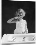 1930s child curly hair blond girl brushing teeth toothbrush looking at camera by Anonymous