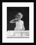 1930s child curly hair blond girl brushing teeth toothbrush looking at camera by Anonymous