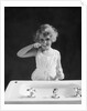 1930s child curly hair blond girl brushing teeth toothbrush looking at camera by Anonymous