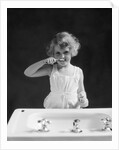 1930s child curly hair blond girl brushing teeth toothbrush looking at camera by Anonymous