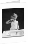 1930s child curly hair blond girl brushing teeth toothbrush looking at camera by Anonymous