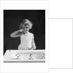 1930s child curly hair blond girl brushing teeth toothbrush looking at camera by Anonymous