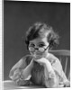 1930s portrait little girl smiling wearing big round eyeglasses looking at camera by Anonymous