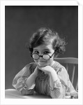 1930s portrait little girl smiling wearing big round eyeglasses looking at camera by Anonymous