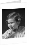 1930s little girl with finger to lips making quiet gesture looking at camera by Anonymous