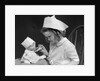 1930s little girl playing nurse with doll spoonful of medicine by Anonymous