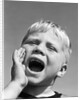 1950s blond boy with eyes closed and hand cupping a wide open mouth shouting by Anonymous