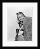 1940s little girl holding doll peeking around side of chair by Anonymous