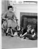 1950s mother watching son daughter playing game in front of fireplace by Anonymous