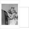 1930s 1940s child blond little girl with pigtails putting letter into mail box, looking at camera by Anonymous