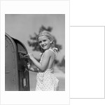 1930s 1940s child blond little girl with pigtails putting letter into mail box, looking at camera by Anonymous