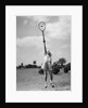 1930s girl playing tennis jumping to hit ball overhead by Anonymous