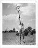 1930s girl playing tennis jumping to hit ball overhead by Anonymous