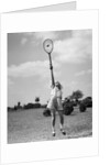 1930s girl playing tennis jumping to hit ball overhead by Anonymous