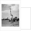 1930s girl playing tennis jumping to hit ball overhead by Anonymous