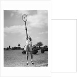 1930s girl playing tennis jumping to hit ball overhead by Anonymous