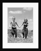 1950s boy girl running grassy farm field holding hands by Anonymous