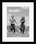 1950s boy girl running grassy farm field holding hands by Anonymous