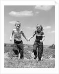 1950s boy girl running grassy farm field holding hands by Anonymous