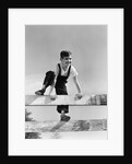 1940s brunette boy wearing overalls climbing over fence by Anonymous