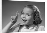 1950s little girl string tied on finger as reminder not to forget smiling looking at camera by Anonymous