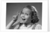 1950s little girl string tied on finger as reminder not to forget smiling looking at camera by Anonymous
