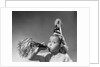 1950s girl wearing party hat blowing into noise maker looking at camera by Anonymous
