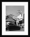 1950s child typing sitting at typewriter by Anonymous