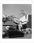 1950s child typing sitting at typewriter by Anonymous