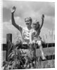 1930s girl sitting on fence with woman next to her in field waving by Anonymous