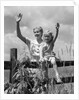 1930s girl sitting on fence with woman next to her in field waving by Anonymous