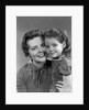 1950s girl daughter smiling hugging woman mother cheek to cheek together by Anonymous