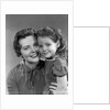 1950s girl daughter smiling hugging woman mother cheek to cheek together by Anonymous