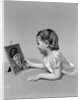 1940s child little girl looking at framed picture of her father a soldier in uniform by Anonymous