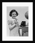 1930s child smiling girl putting money coin into toy cash register bank by Anonymous