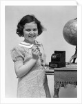 1930s child smiling girl putting money coin into toy cash register bank by Anonymous