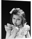 1950s child serious little girl pressing finger to lips hush be quiet secret by Anonymous