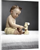 1940s 1950s baby sitting touching toy dog by Anonymous