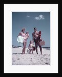 1950s family man woman mother father children boy girl son daughter standing sandy beach with toys and picnic basket by Anonymous