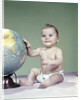 1960s smiling baby girl sitting in diapers hand touching world globe by Anonymous