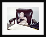 1960s chubby baby sitting in leather chair at office desk holding telephone by Anonymous